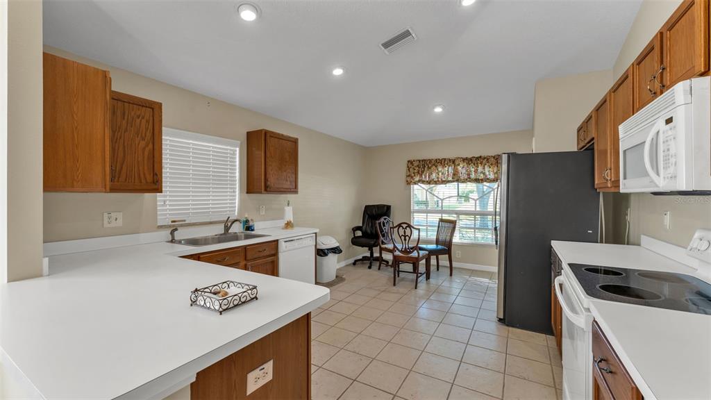 2729 Pankaw Lane Valrico, FL 33596 - Photo 10 of 41 a kitchen with furniture a stove a sink a dining table and chairs