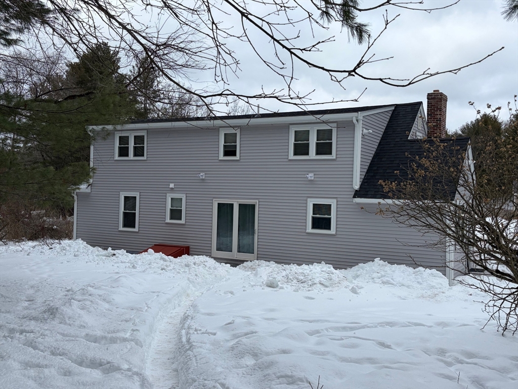 98 West Street Georgetown, MA 01833 - Photo 4 of 39 a front view of a house with a yard covered in snow