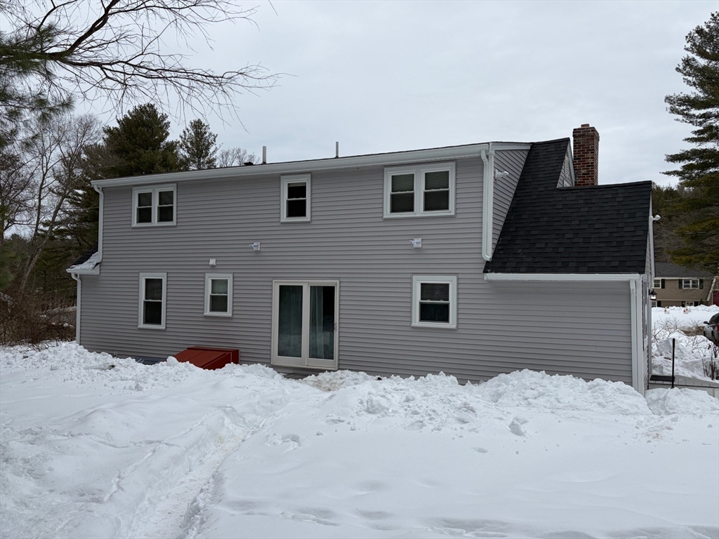 98 West Street Georgetown, MA 01833 - Photo 5 of 39 a front view of a house with a yard covered in snow