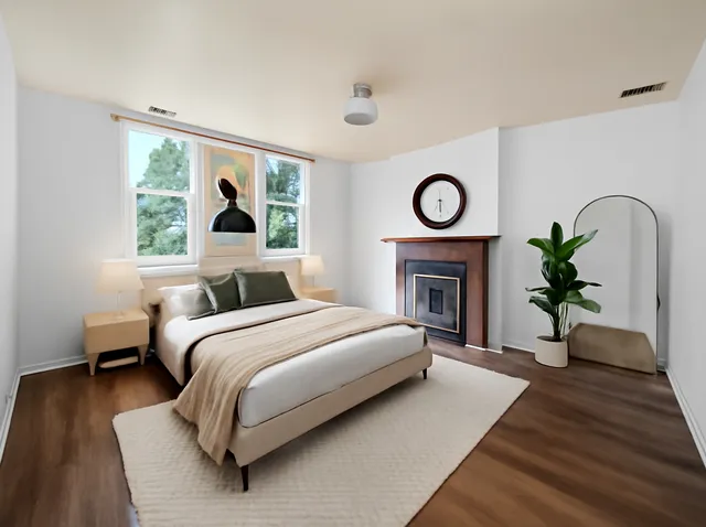 a bed sitting in a spacious bedroom with a fireplace and a table
