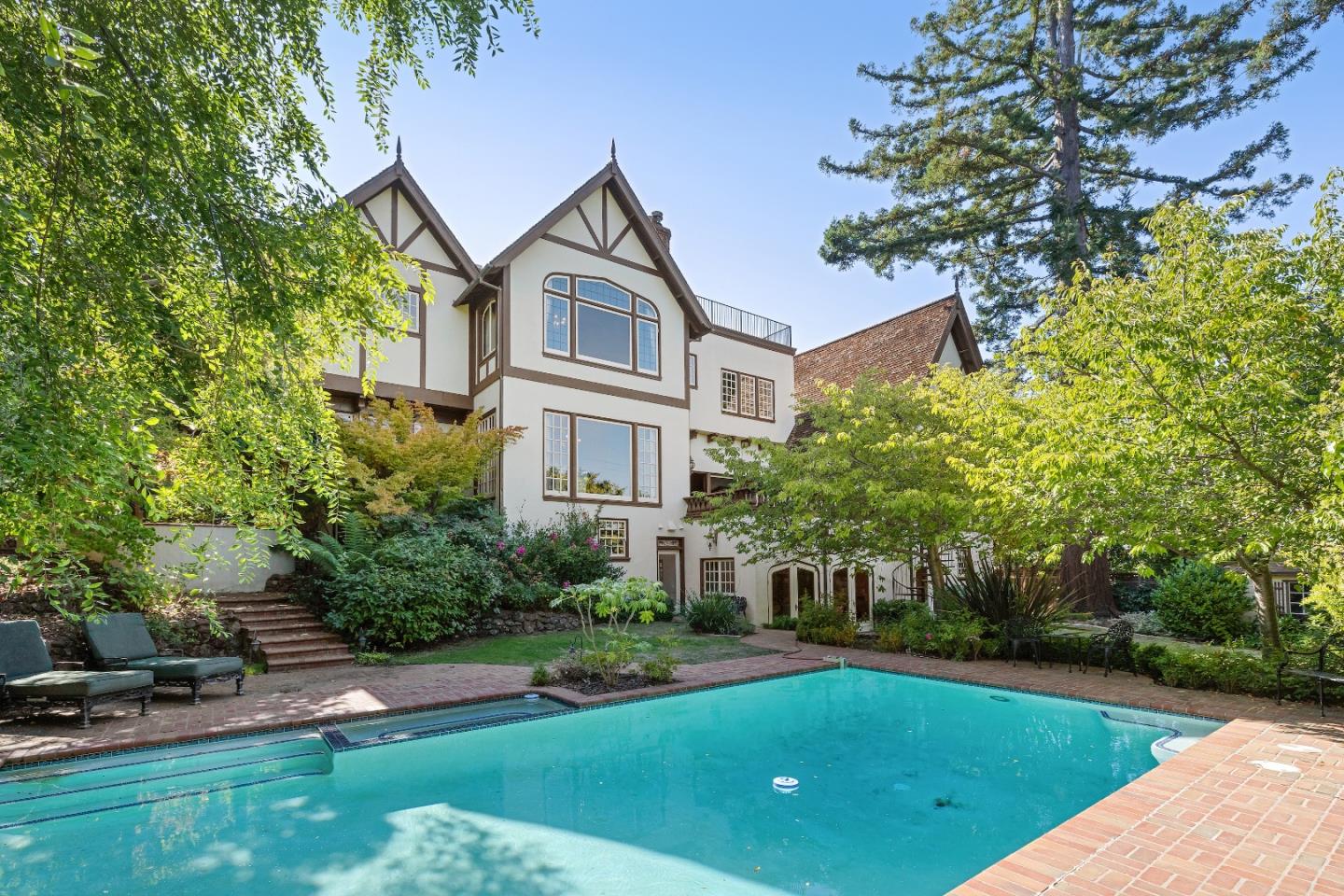 446 El Arroyo Road Hillsborough, CA 94010 - Photo 27 of 32 a front view of a house with a yard table and chairs