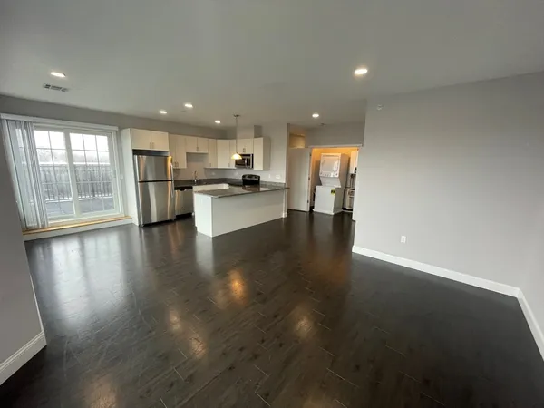 a view of a living room and kitchen with furniture wooden floor and kitchen view