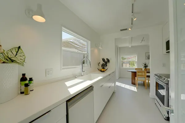 a large white kitchen with a large window