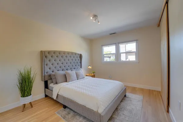 a bedroom with a bed and a potted plant