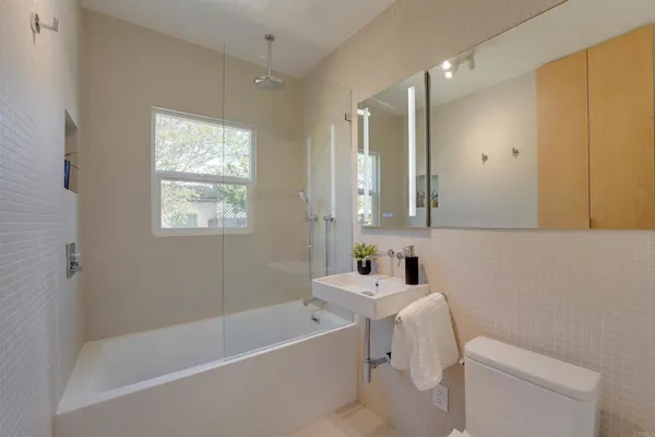 a bathroom with a bathtub a sink a toilet and a mirror