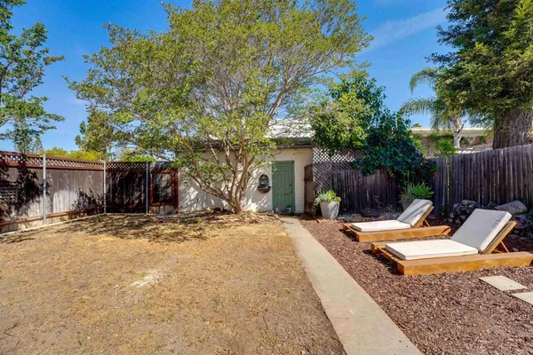 a backyard of a house with table and chairs