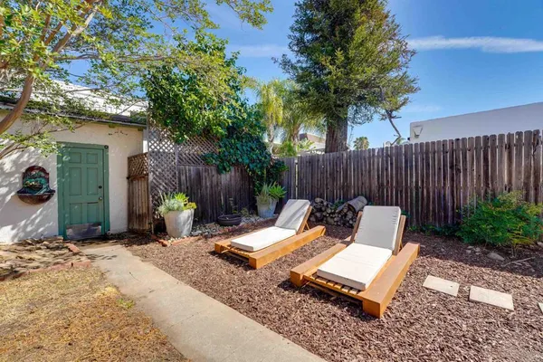 a view of a lounge chairs in back yard of the house
