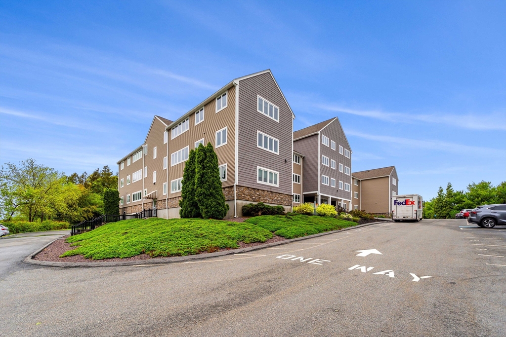 36 Dunham Road, Unit 109 Beverly, MA 01915 - Photo 20 of 22 a front view of a house with a yard and garage