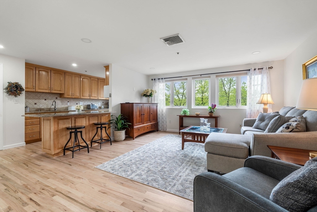 36 Dunham Road, Unit 109 Beverly, MA 01915 - Photo 4 of 22 a living room with furniture and a large window