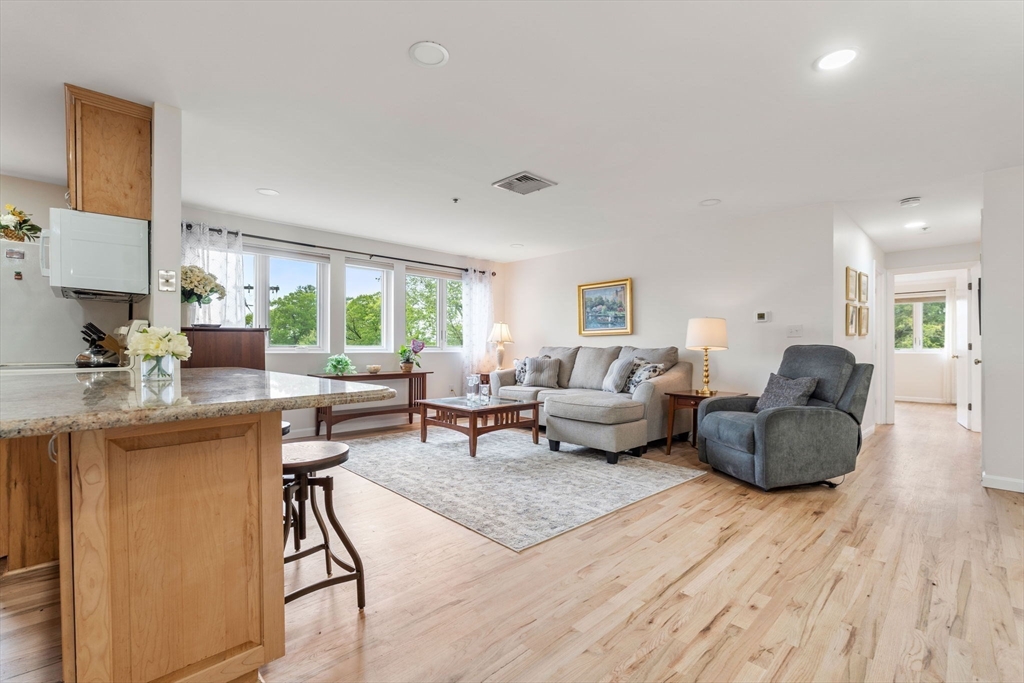36 Dunham Road, Unit 109 Beverly, MA 01915 - Photo 5 of 22 a living room with furniture and a wooden floor