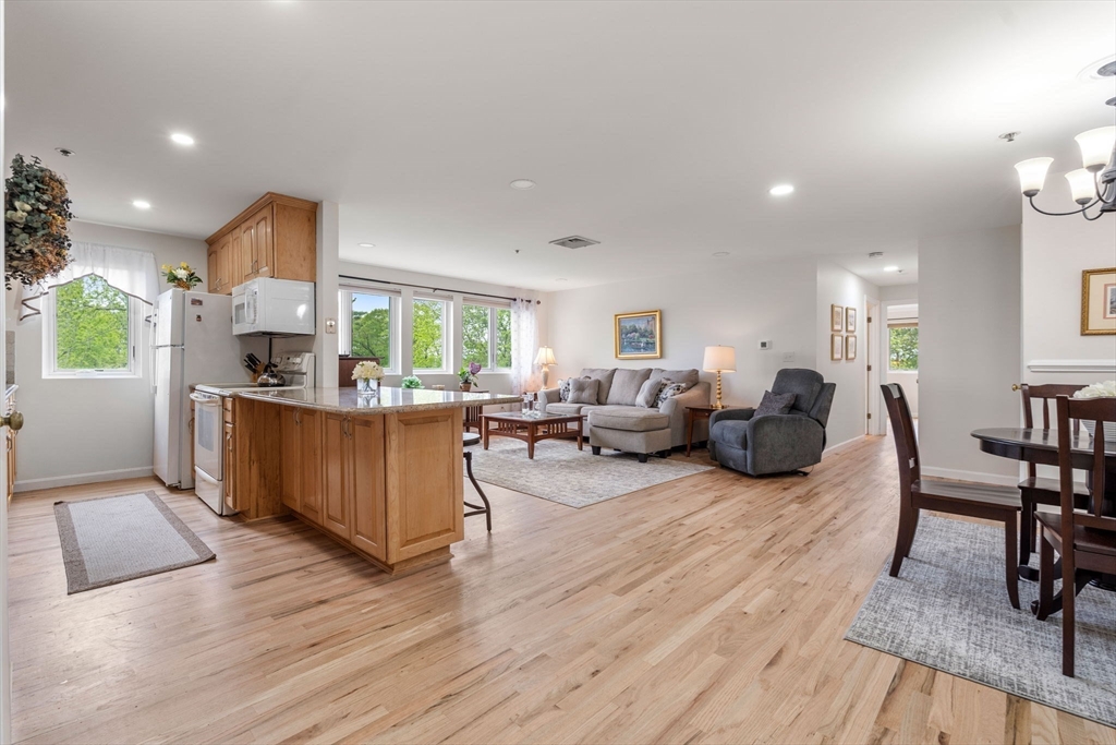 36 Dunham Road, Unit 109 Beverly, MA 01915 - Photo 6 of 22 a living room with furniture kitchen view and a wooden floor