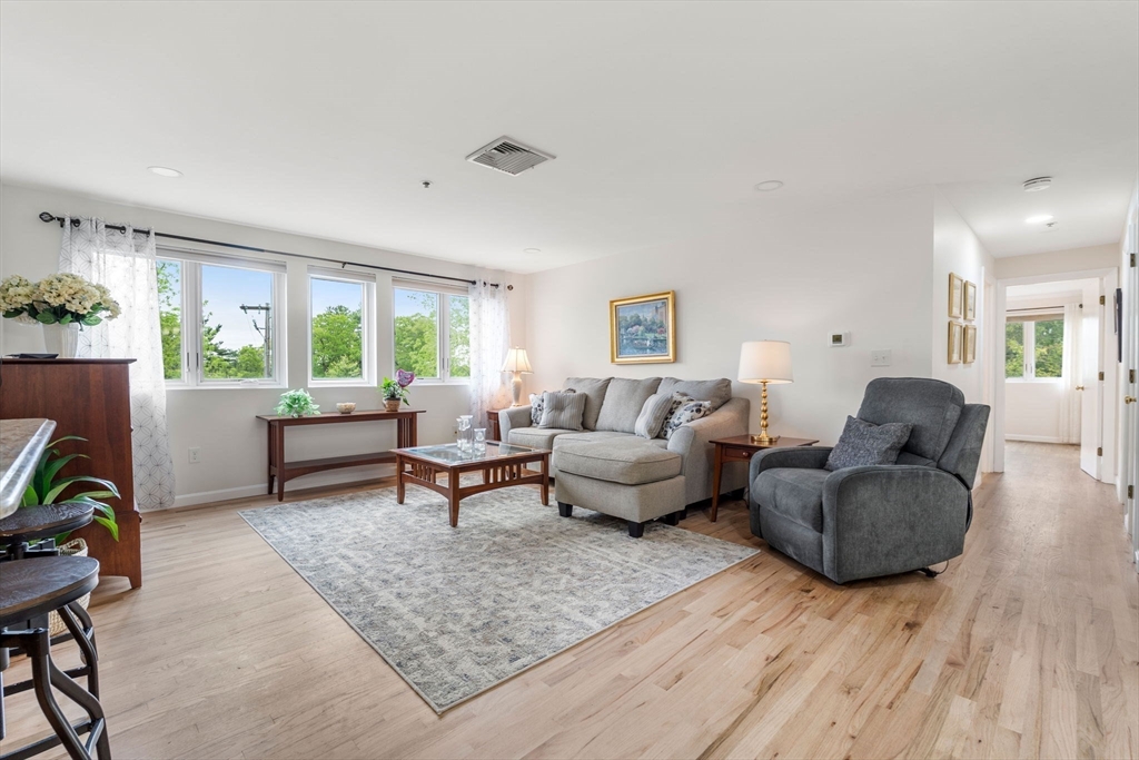36 Dunham Road, Unit 109 Beverly, MA 01915 - Photo 8 of 22 a living room with furniture and a wooden floor