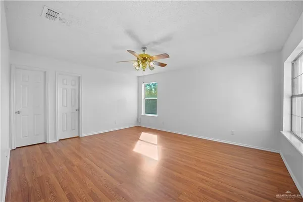 a view of empty room with window and wooden floor