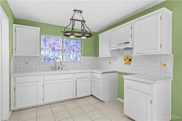 a kitchen with white cabinets and white appliances