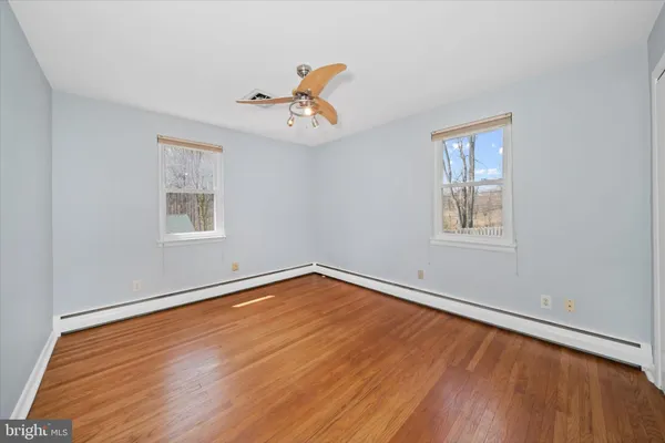a view of a room with wooden floor and ceiling fan