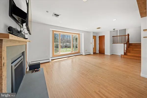 a view of an empty room with a fireplace and a window
