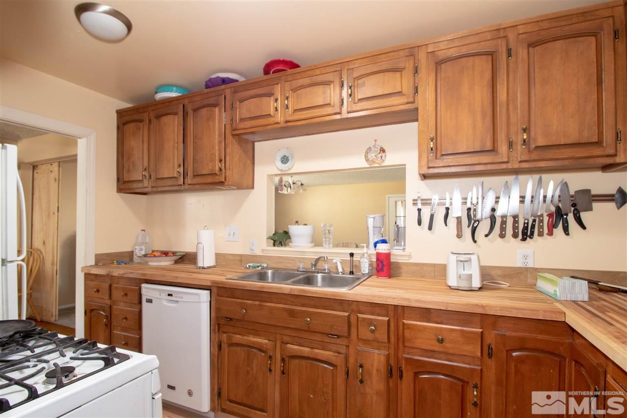 520 Claremont Street Reno, NV 89502 - Photo 8 of 22 a kitchen with granite countertop a sink dishwasher stove and cabinets