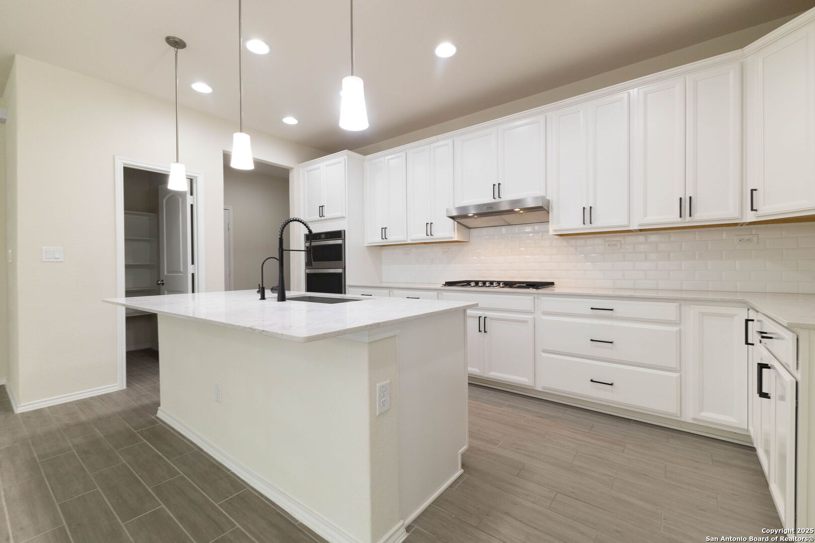 353 Aberdeen Boerne, TX 78015 - Photo 12 of 36 a kitchen with white cabinets and stainless steel appliances
