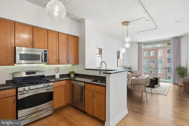 a kitchen with granite countertop a refrigerator stove and microwave