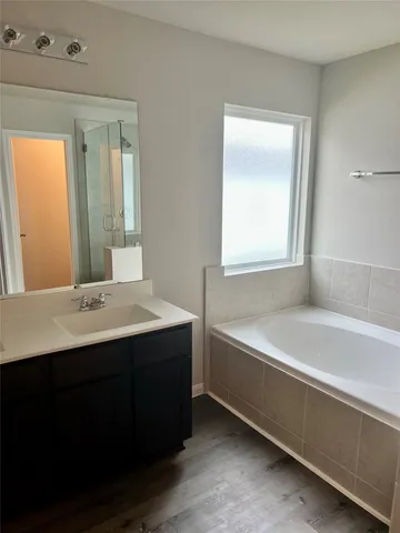 a bathroom with a bathtub a sink and a window