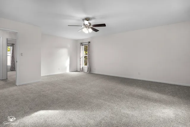 a view of a livingroom with a ceiling fan and window