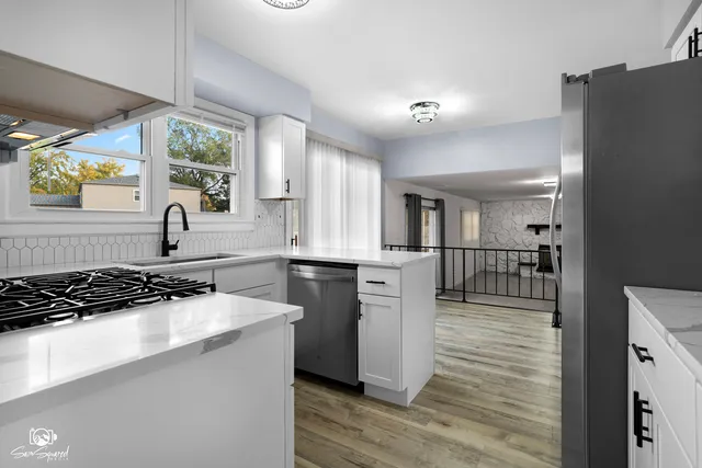 a kitchen with stainless steel appliances granite countertop a sink stove and refrigerator