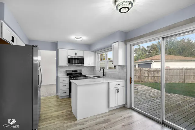 a kitchen with stainless steel appliances granite countertop a refrigerator a stove and a sink