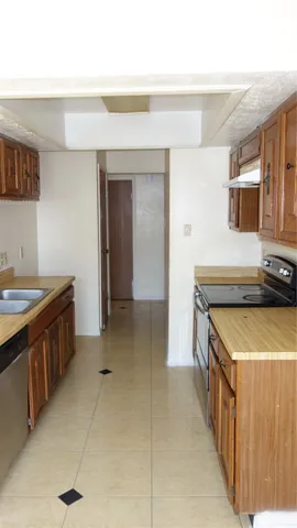 a kitchen with stainless steel appliances a sink stove and cabinets