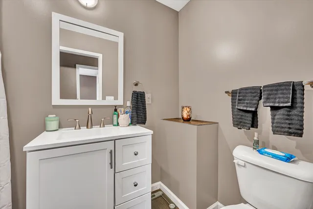 a bathroom with a toilet sink and mirror