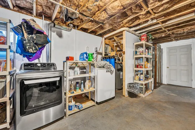 a utility room with fridge dryer and washer