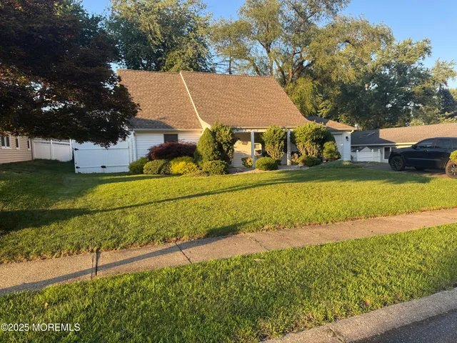 an aerial view of a house with a yard and lake view