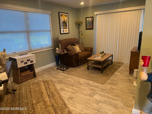 an empty room with wooden floor and bathroom
