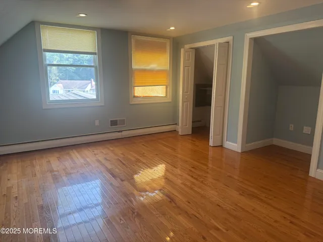 a view of empty room with wooden floor