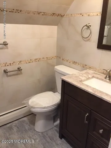 a bathroom with a granite countertop sink and white cabinets