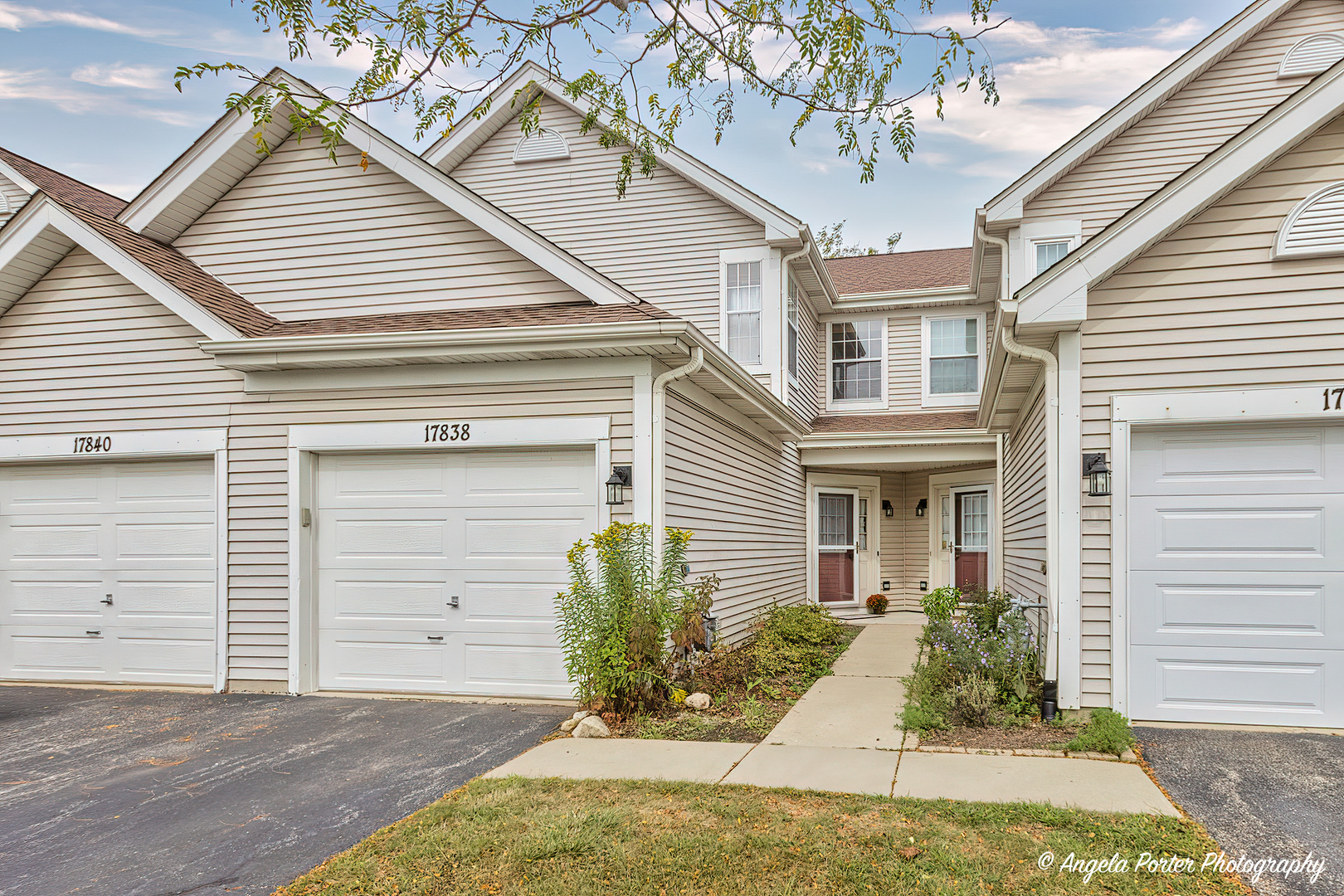 17838 Braewick Road, Unit 16017 Gurnee, IL 60031 - Photo 1 of 28 a view of a white house potted plants and a large tree
