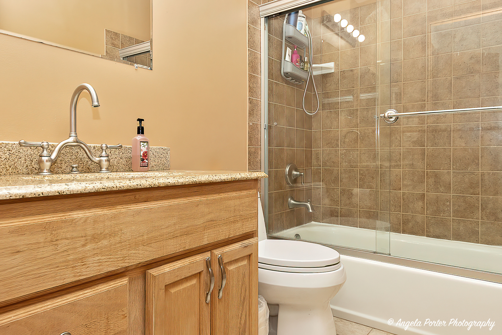 17838 Braewick Road, Unit 16017 Gurnee, IL 60031 - Photo 24 of 28 a bathroom with a granite countertop bathtub sink vanity mirror and toilet