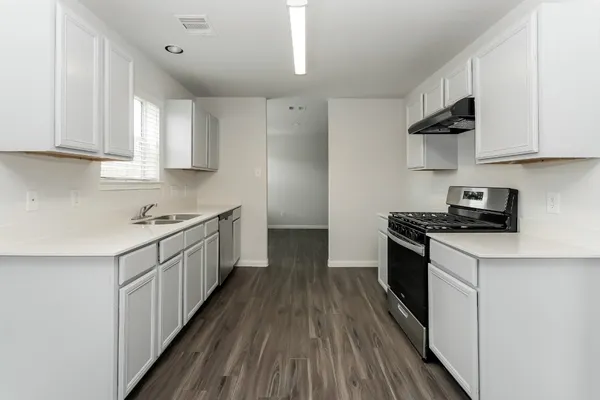 a kitchen with cabinets a sink and appliances