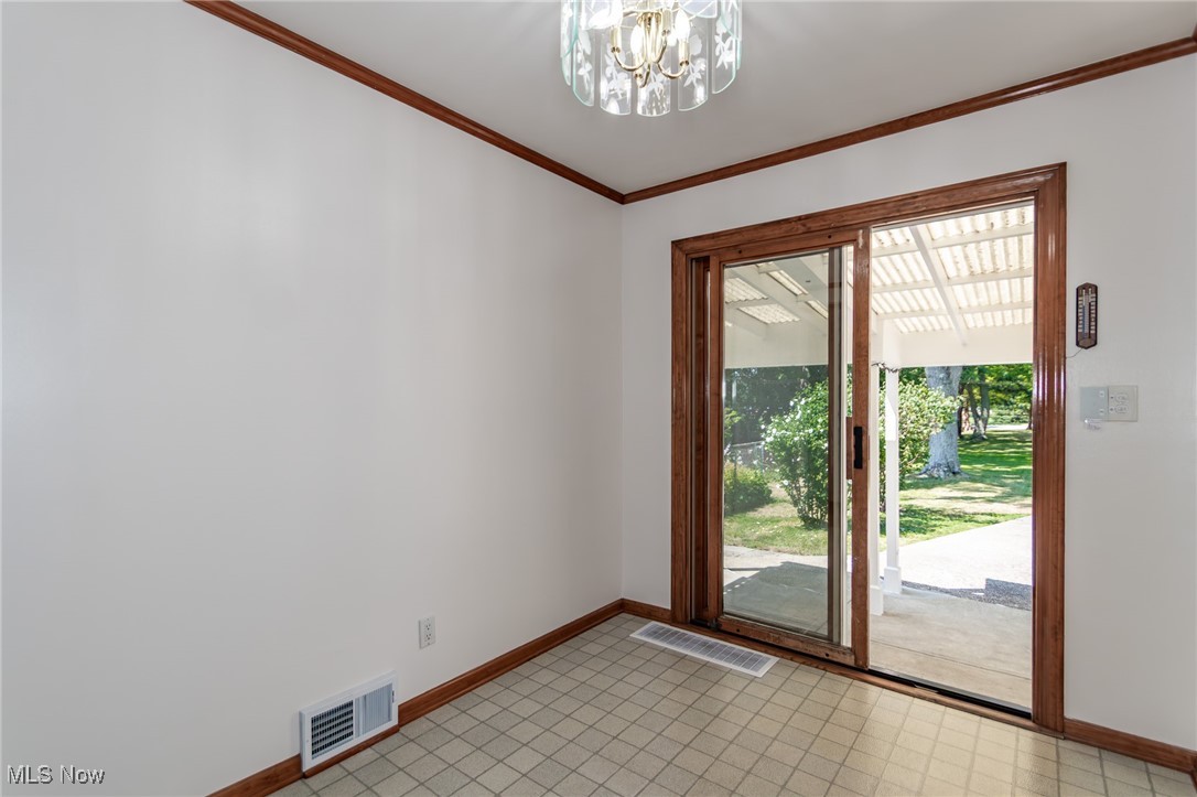 5223 Edenhurst Road Cleveland, OH 44124 - Photo 18 of 50 Empty room with a chandelier and ornamental molding