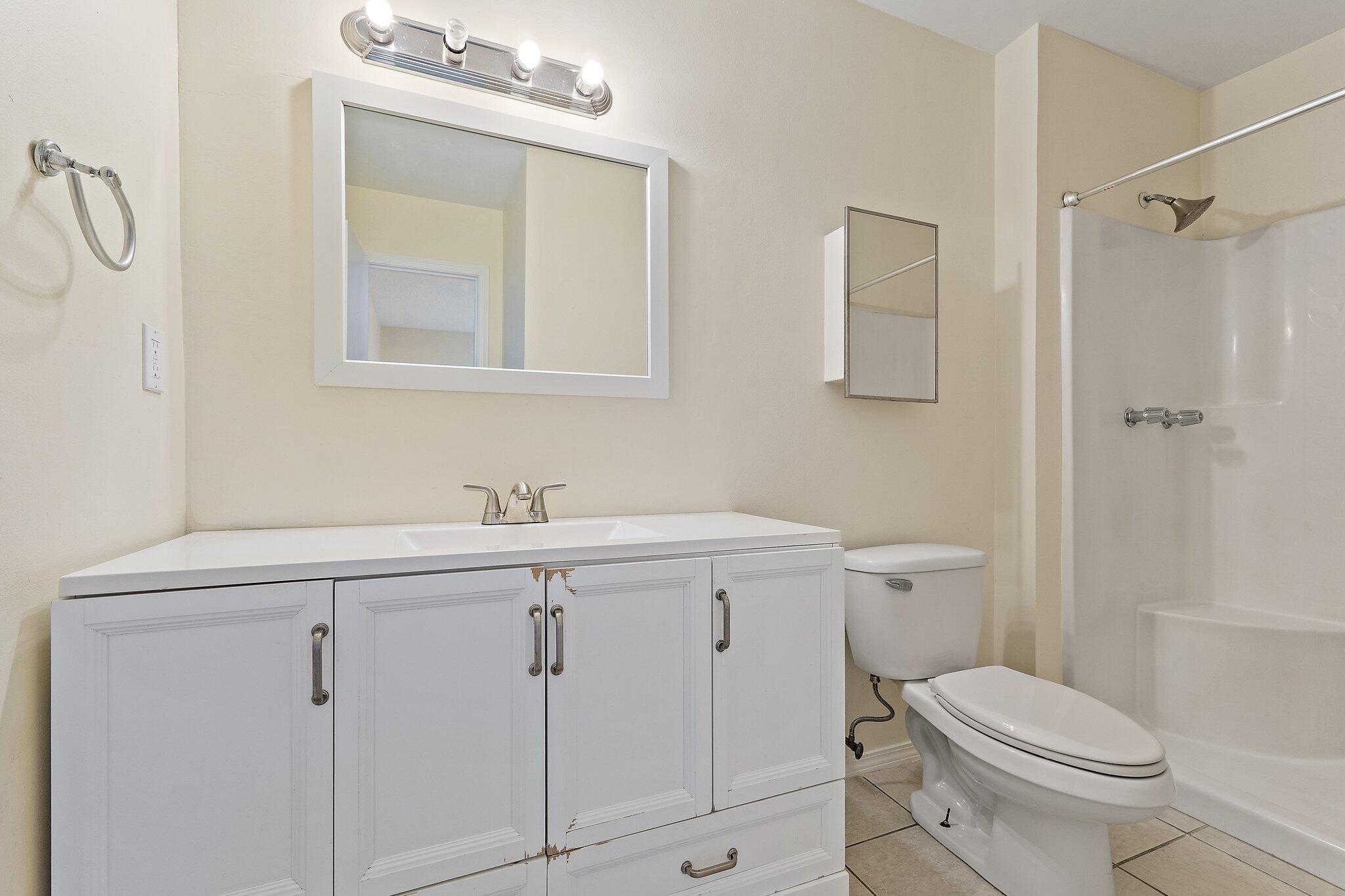 3581 Southeast Cobia Way Stuart, FL 34997 - Photo 20 of 26 a bathroom with a sink a toilet and shower