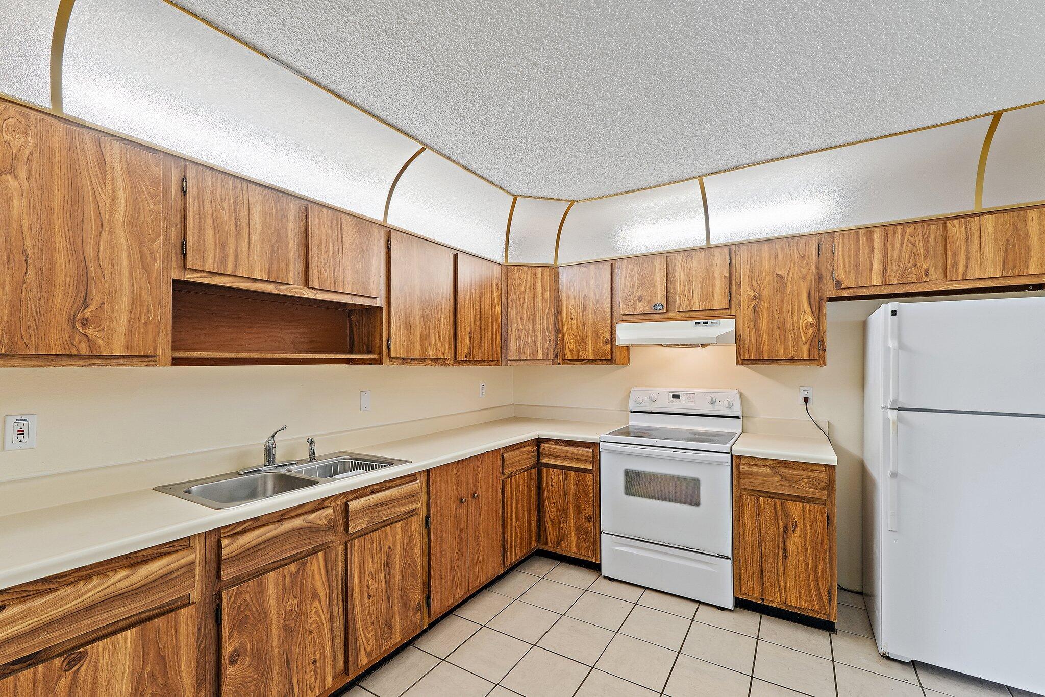 3581 Southeast Cobia Way Stuart, FL 34997 - Photo 9 of 26 a kitchen with a sink a stove and refrigerator