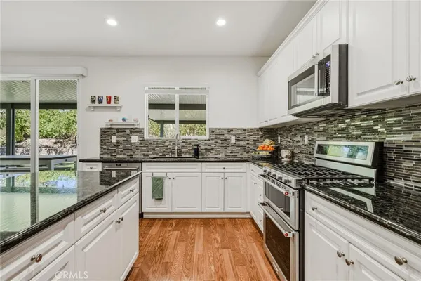 a kitchen with stainless steel appliances granite countertop a stove and a sink