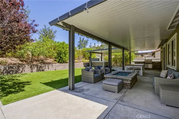 a view of patio with couches table and chairs with wooden floor and fence