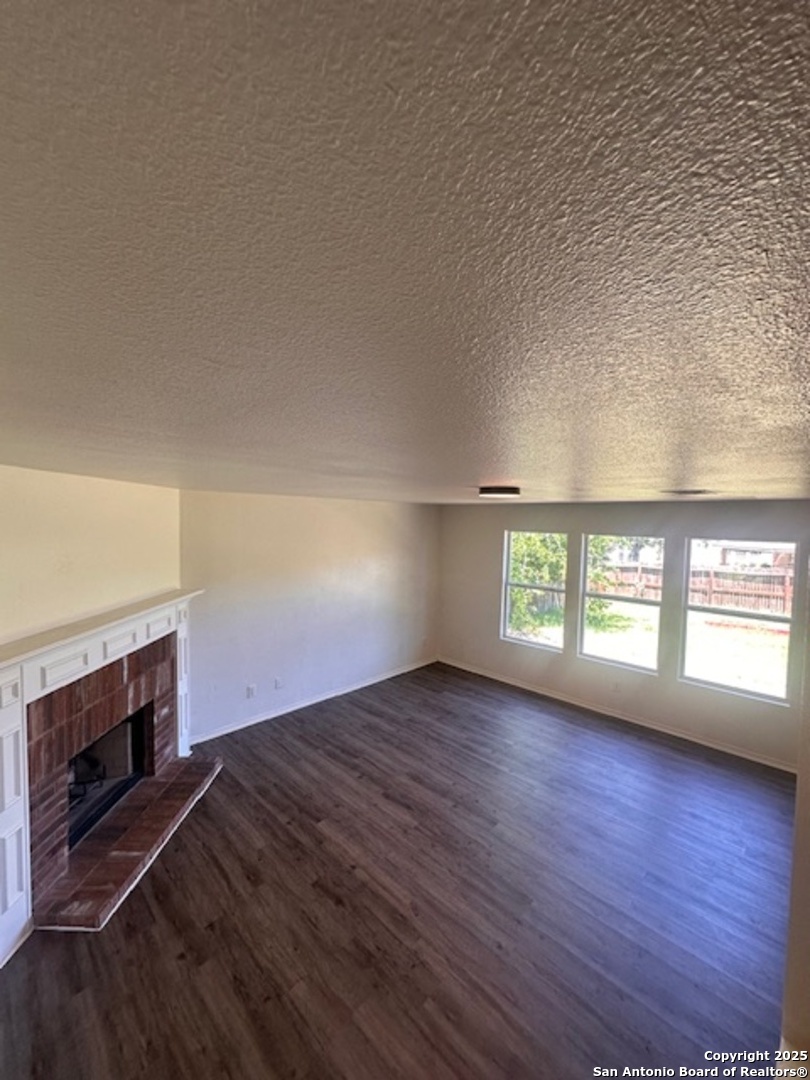1667 Spice San Antonio, TX 78260 - Photo 5 of 25 an empty room with wooden floor fireplace and windows