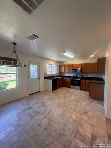 a large kitchen with kitchen island a sink stainless steel appliances and cabinets