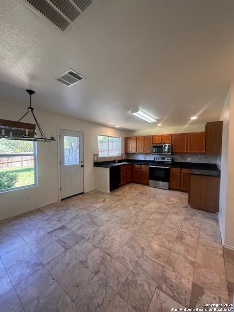 1667 Spice San Antonio, TX 78260 - Photo 8 of 25 a large kitchen with kitchen island a sink stainless steel appliances and cabinets
