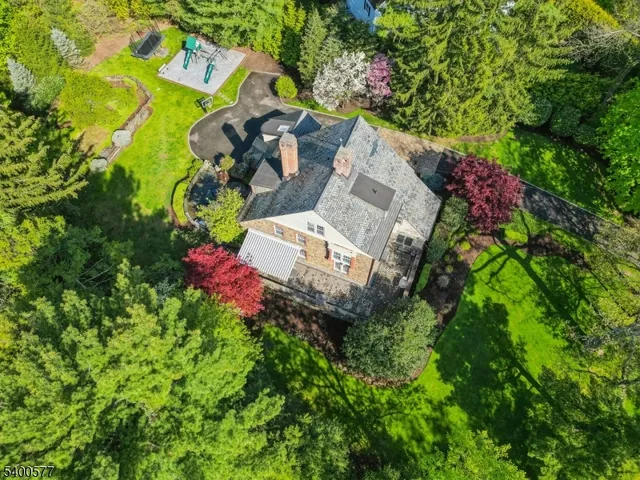 an aerial view of residential house with outdoor space and trees all around