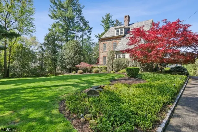 a front view of a house with a yard and potted plants