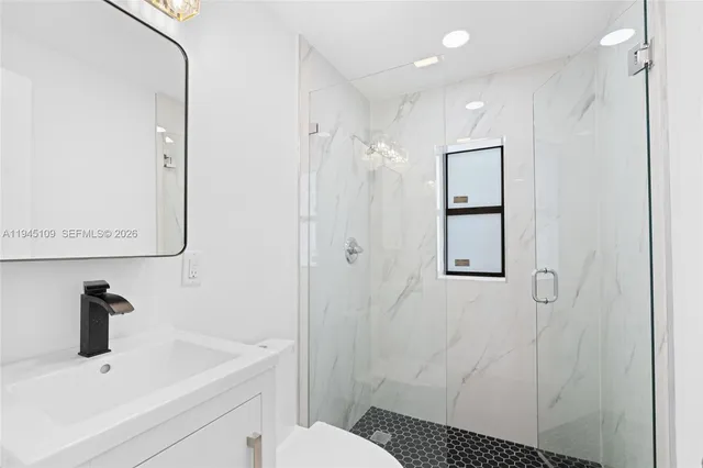 a bathroom with a sink a toilet and shower