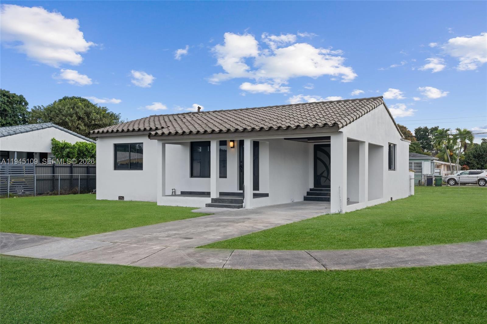 3030 Northwest 99th Street Miami, FL 33147 - Photo 2 of 27 a front view of a house with a garden and patio