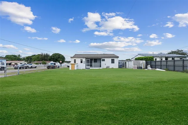 an aerial view of a house having yard swimming pool and ocean view